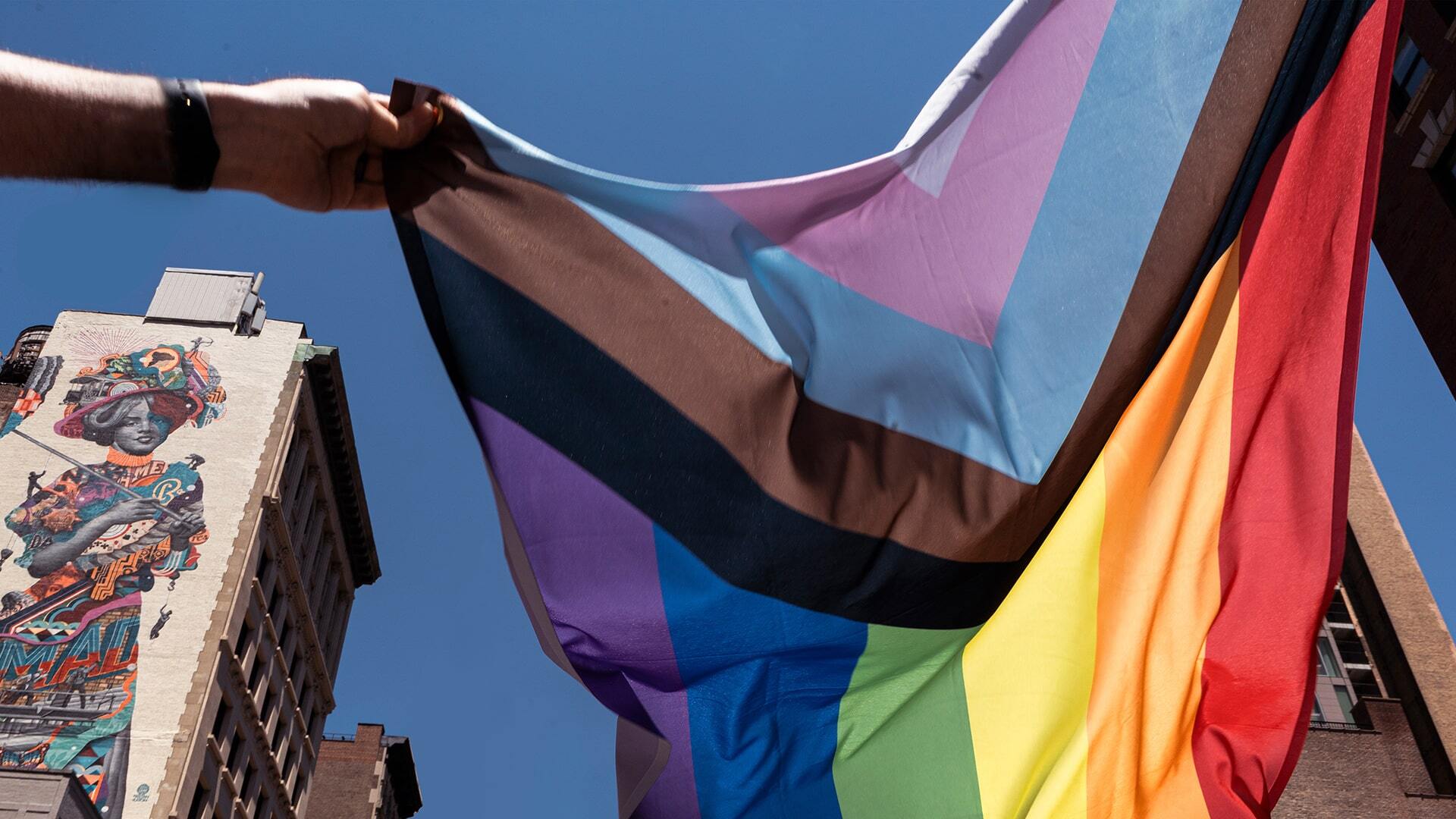 Outright-International-The Giving Block Photo of person holding Pride Flag